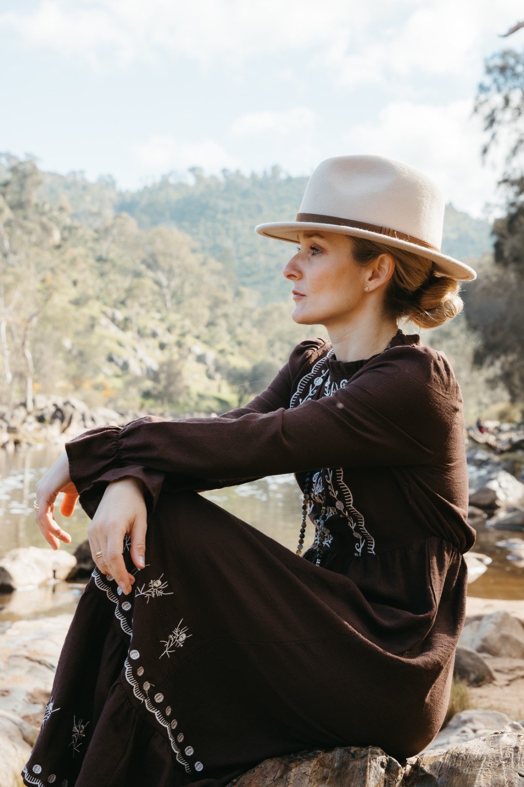 Shana seated quietly by the river in the Western Australian bush